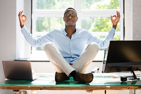 Man meditating on office desk